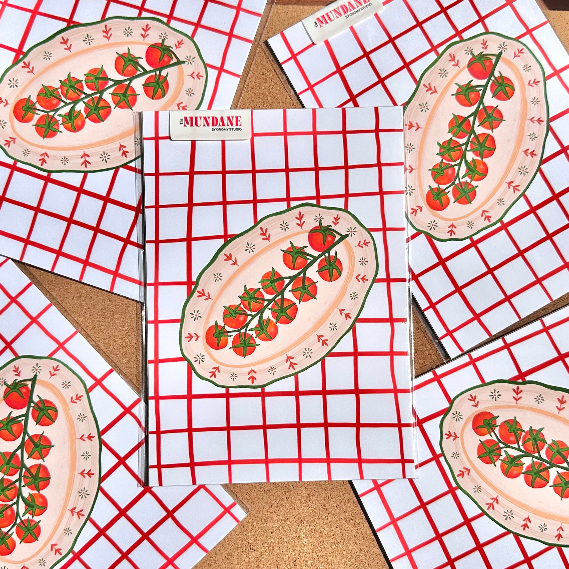 Placemats with tomato design on a red and white checkered tablecloth.