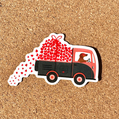 Sticker of a truck with hearts and a dog on a cork background