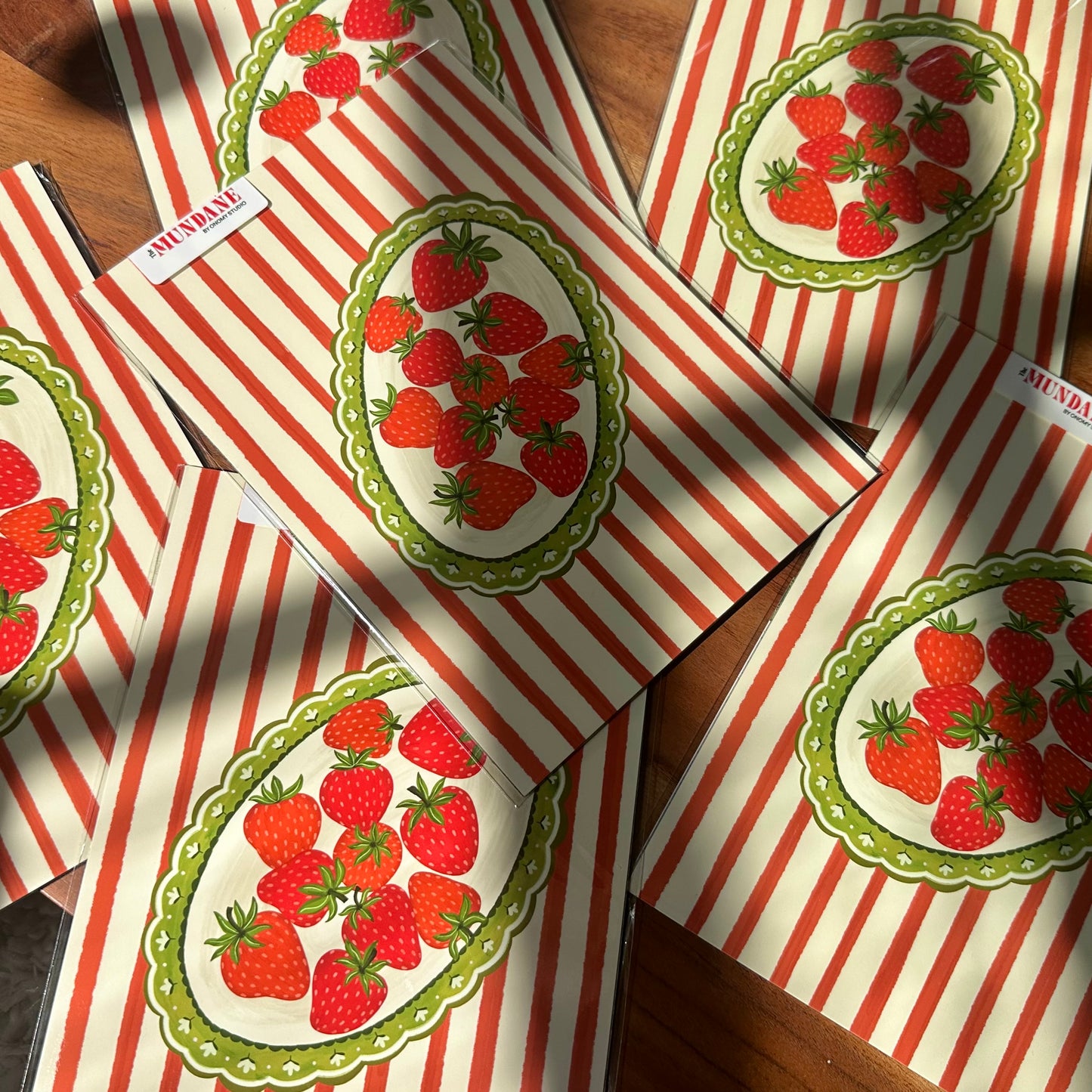 Red and white striped boxes with strawberry design on a wooden surface