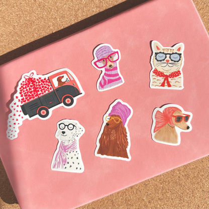 Set of stickers featuring animals in cute outfits on a pink surface.