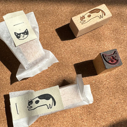 Cat-themed rubber stamps and stamp pads on a cork surface