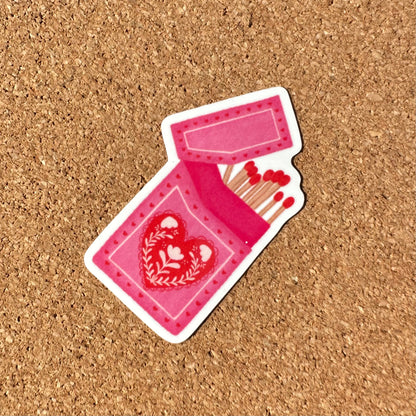 Pink matchbox with heart design on a cork background