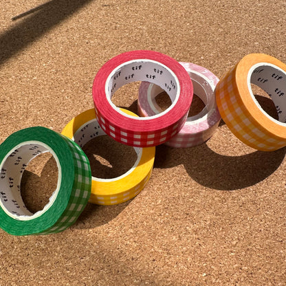 Colorful washi tape rolls on a cork surface