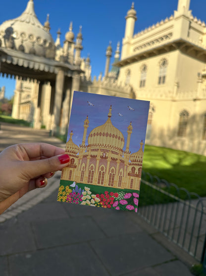 Hand holding a card with a colorful illustration of a building against a real-world backdrop