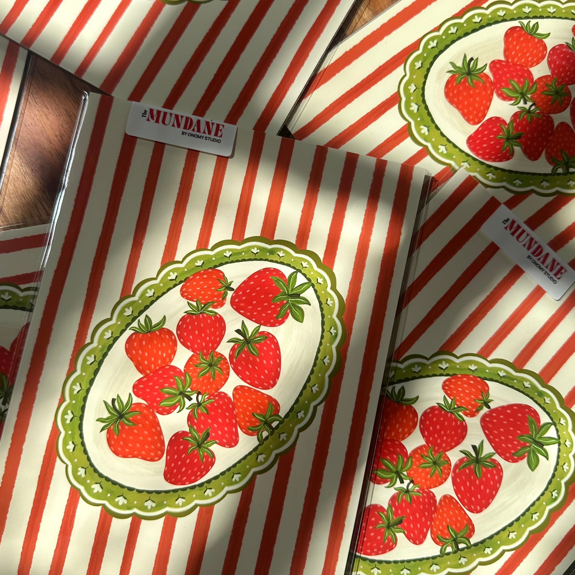 Red and white striped packages with strawberry design and 'Mundane' branding.