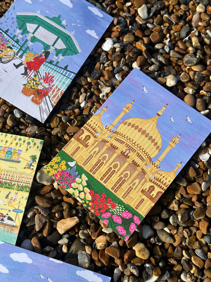 Three colorful postcards with artistic designs on a pebble surface