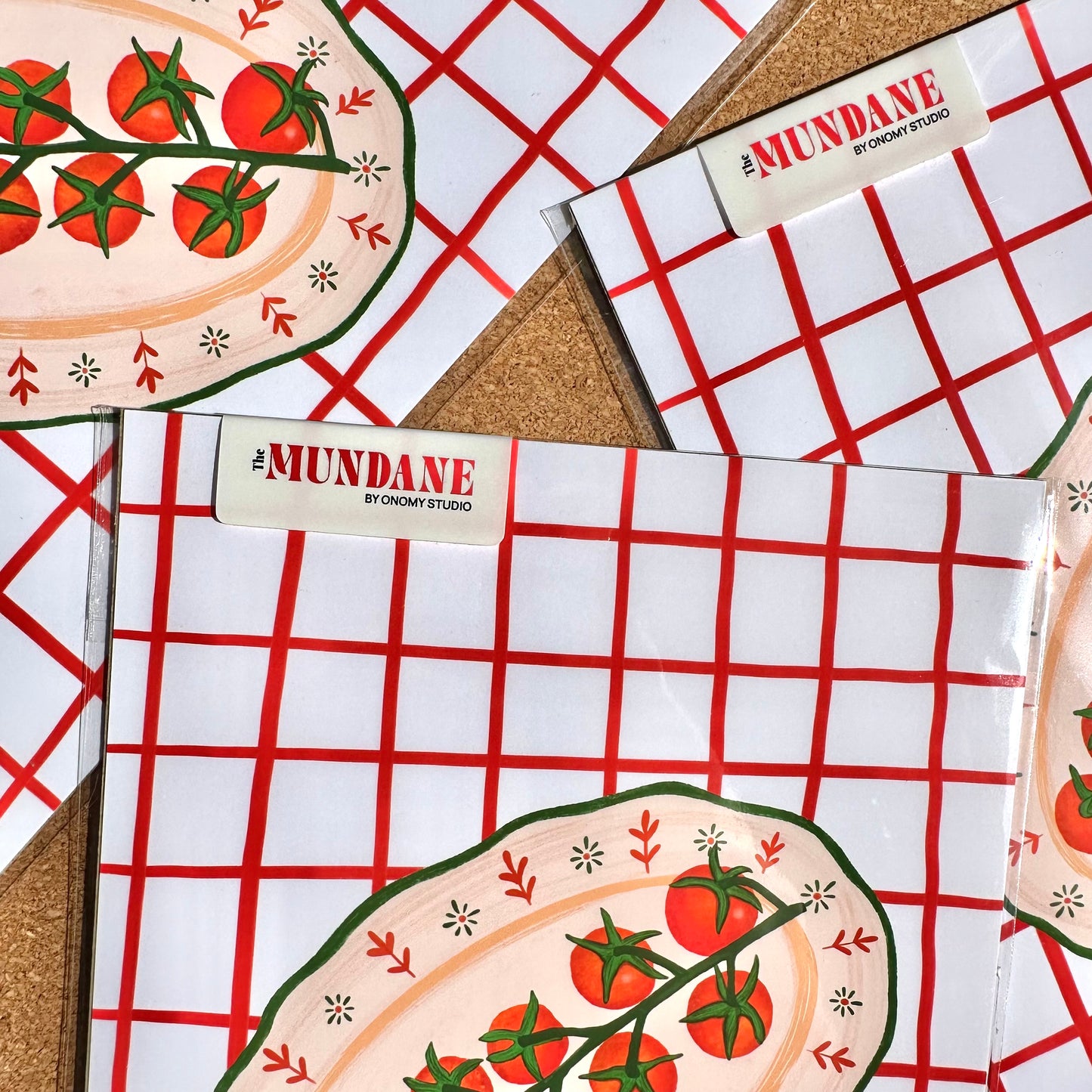 Notebooks with red grid pattern and pizza illustration on a checkered surface