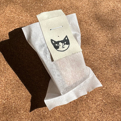 White paper towel with black cat illustration on a cork surface
