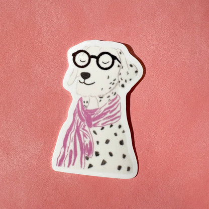 Sticker of a dalmatian dog wearing glasses and a pink scarf on a pink background