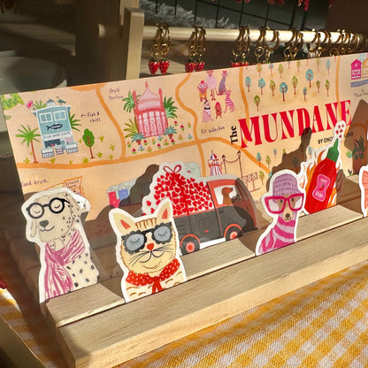 Card holder with illustrated characters and a map design on a wooden stand.