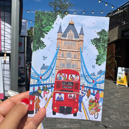 Close up detail of Tower Bridge illustration postcard, London souvenir with hand drawn Thames and red bus
