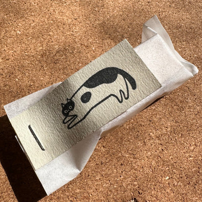 Small box with a cat illustration on a cork surface