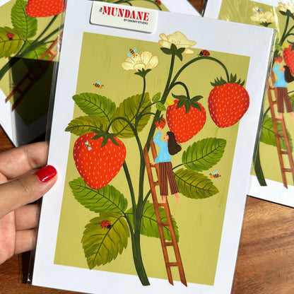 Illustrated card with a strawberry plant and person on a ladder, held by a hand.