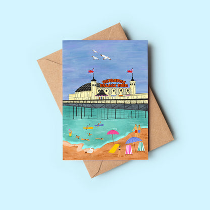 Greeting card with a beach scene and building illustration, placed on a light blue background.