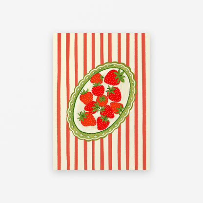 Notebook with red and white striped cover featuring a green border and red strawberry design.