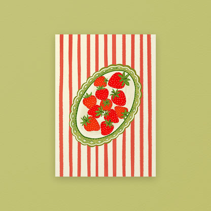 Tea towel with red and white striped pattern and strawberry design on a green background