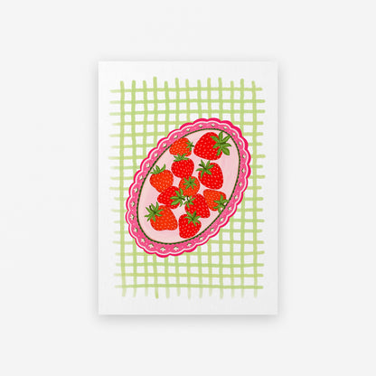 Decorative plate with strawberries on a green checkered background