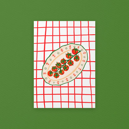 Notebook with a red and white checkered cover featuring a design of a sliced avocado with cherry tomatoes on a green background.