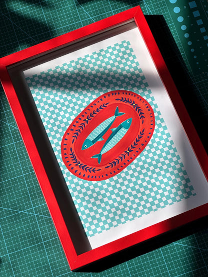 Framed artwork with a red border featuring a blue fish design on a checkered background.